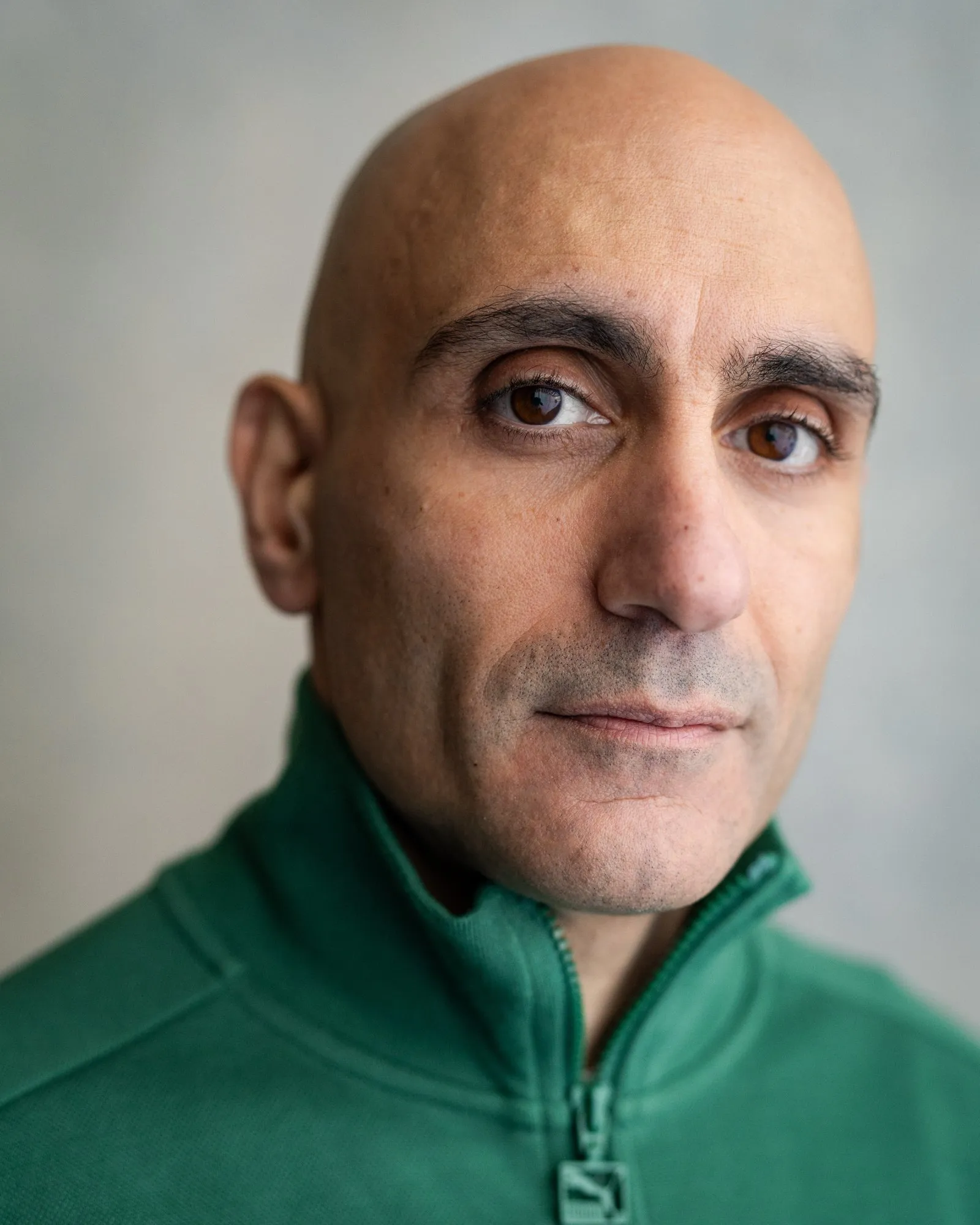 Chris Nicou headshot, green zip jacket